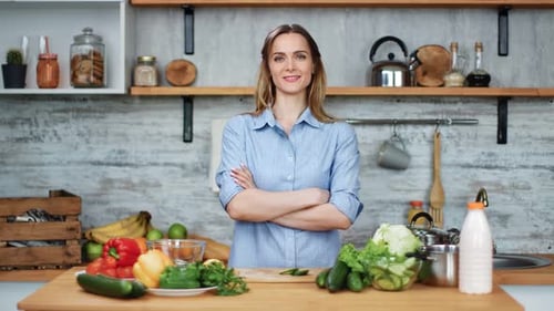 Smiling Woman Standing With Vegetables on Kitchen Counter