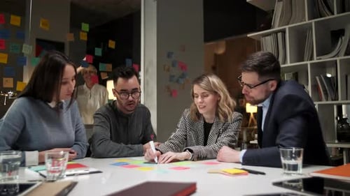 Team Brainstorming Ideas Using Sticky Notes in Office