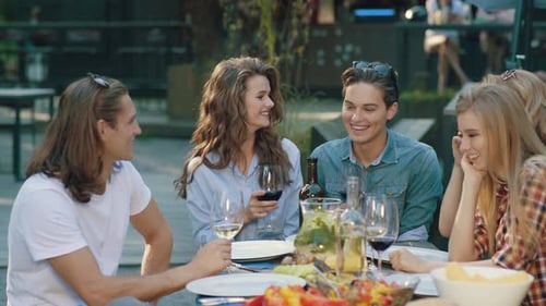 Friends Enjoying Meal at Outdoor Urban Restaurant