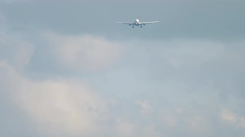 Airplane Flying Through Cloudy Skies Approaching Landing