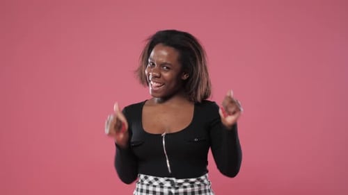 Happy Woman Dances in Studio with Pink Background