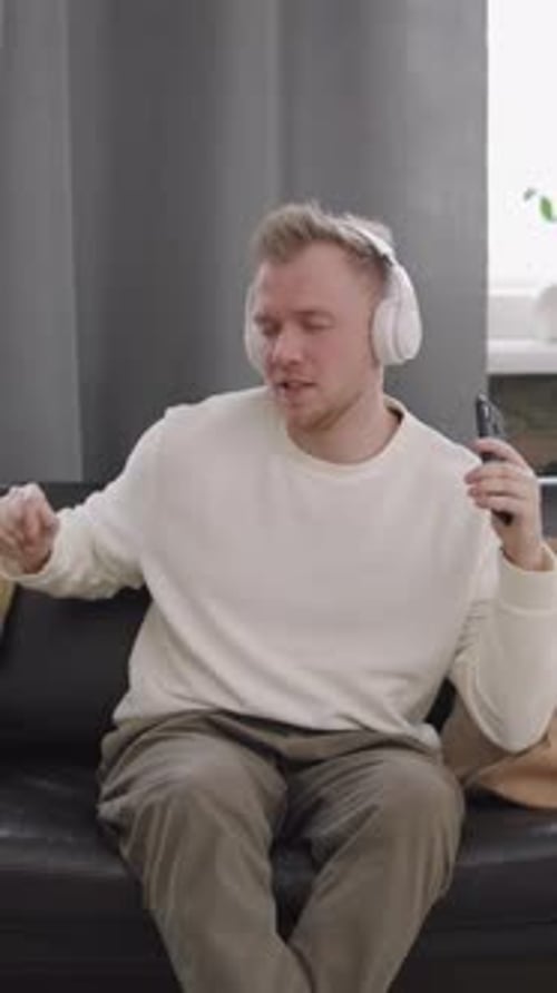 Man Enjoys Music with Headphones at Home