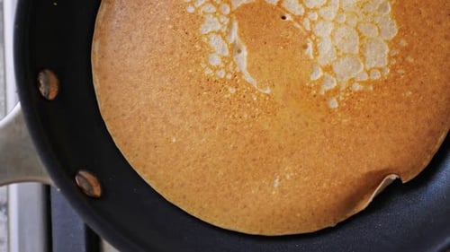 Pancake Cooking on a Black Frying Pan
