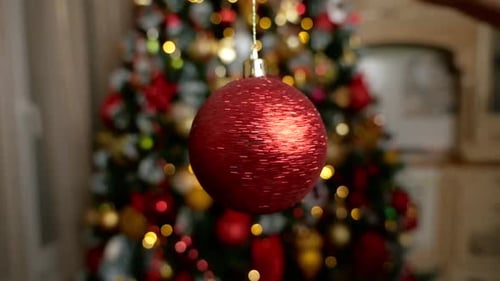 Festive Red Ornament Close Up with Christmas Tree