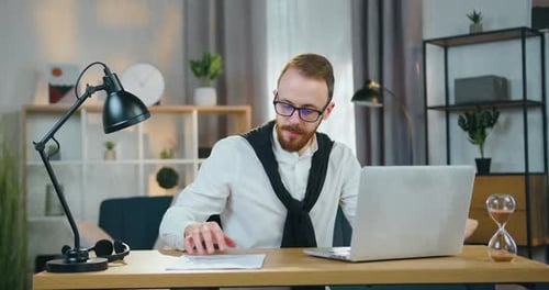 Man Working on Laptop at Desk Indoors