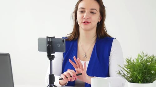 Woman Presenting Online with Laptop and Cellphone