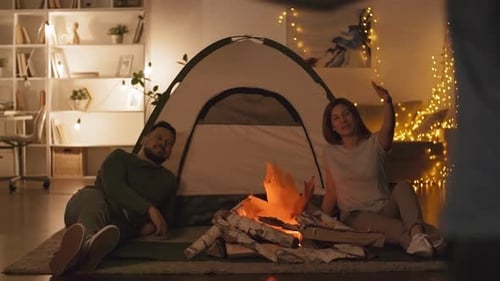 Caucasian Family Sitting by Artificial Bonfire