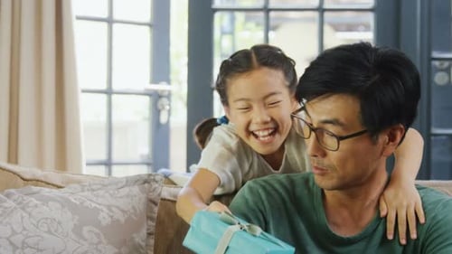 Daughter Gives Father Birthday Gift on Couch