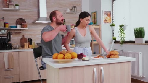Couple Working on Laptop in Kitchen at Home
