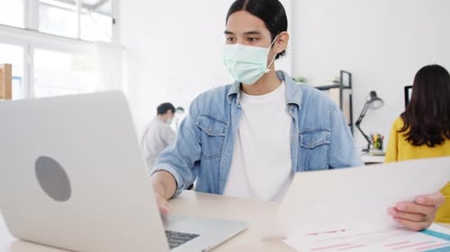 Office Workers Wearing Face Masks Working on Laptops