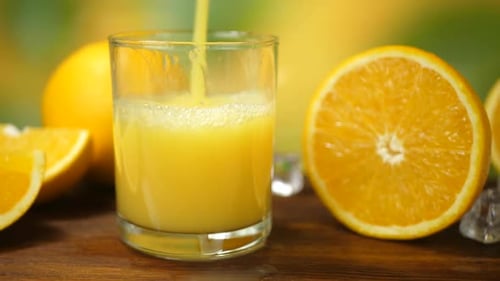 Fresh Orange Juice Poured Into Glass With Ice