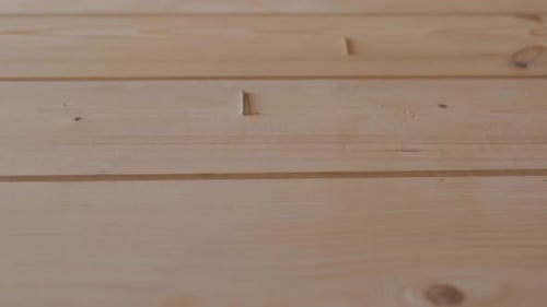 Thin Goldcolored Construction Nails Fall on the Untreated Wooden Surface