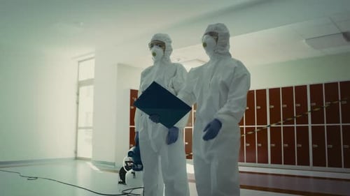 Workers in Hazmat Suits with Cleaning Equipment