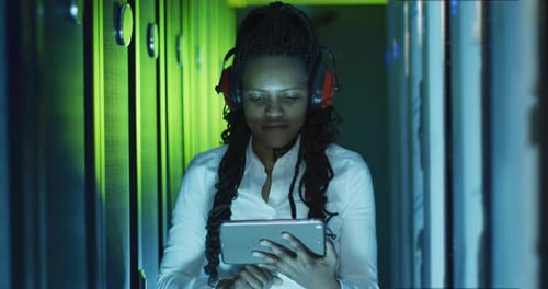 Adult with Tablet in Server Room Smiling