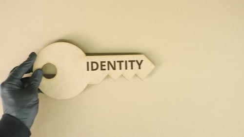 Key to Identity Placed by Gloved Hand