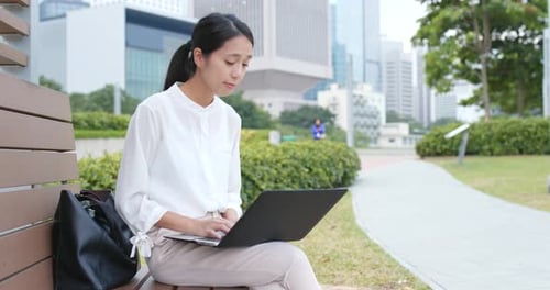 Woman Works on Laptop in Urban Park Setting