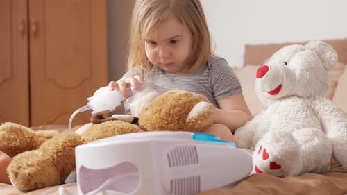 Child Uses Nebulizer with Teddy Bears on Bed