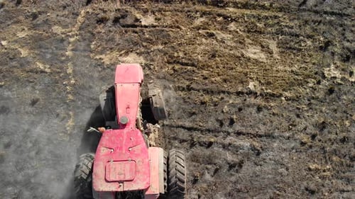 Red, Vintage Tractor Plows the Field with a Reverse Turning Plow, Working on Farmland. Agribusiness