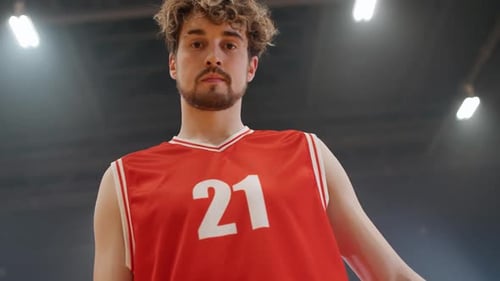 Zeitlupenporträt eines kaukasischen Basketballspielers, der ernsthaft in die Kamera schaut und hält