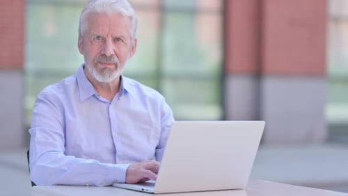 Senior Man Working on Laptop Outdoors