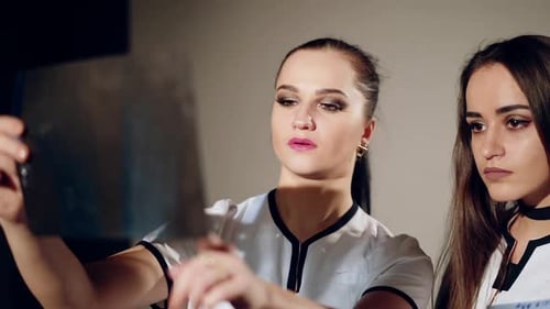 Two Women Analyzing X-Ray in Hospital Setting