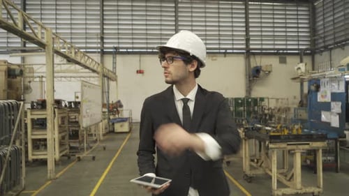 Western businessman, caucasian, an engineer or worker walking in manufacturing factory