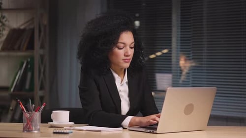 Young Woman Cheers for Success at her Office Desk