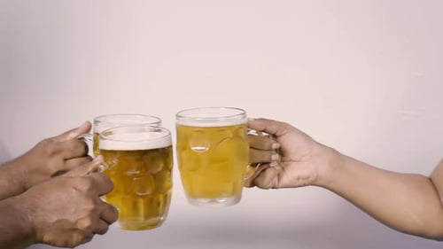 Foaming Beer Mugs Clink Together