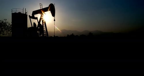 Industrial oil pump jack pumping crude oil for fossil fuel energy with drilling rig in oil field.