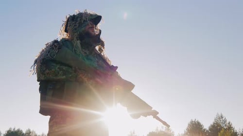 Soldier in Camouflage Holds Rifle in Sunlight