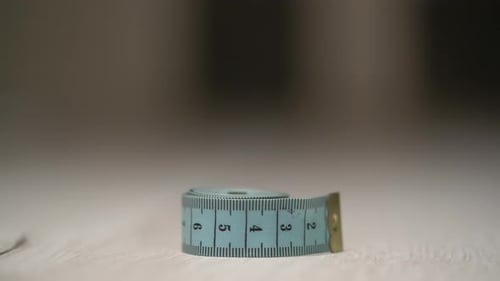 Hand Grabbing a Teal Measuring Tape