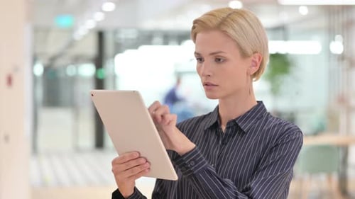 Woman Uses Tablet in Modern Office Environment