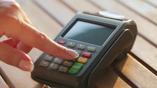Hand Using Credit Card Terminal for Payment