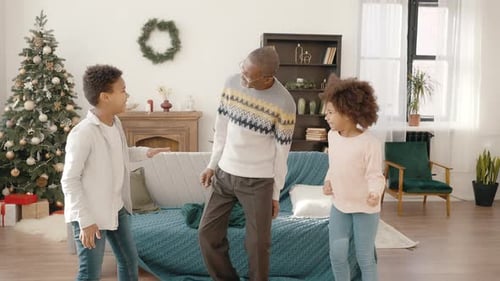 Grandfather and Grandkids Dancing at Christmas Time