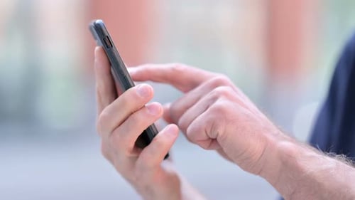 Outdoor Close Up of Hands of Middle Aged Man Using Smartphone