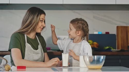 Mother and Daughter Baking Together in Kitchen