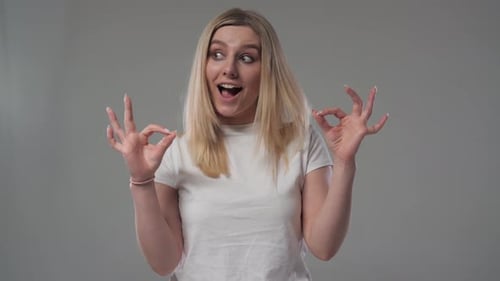 Enthusiastic Woman Making OK Gesture in Studio