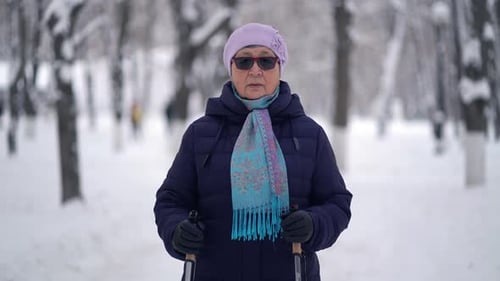 Senior Woman Exercising with Walking Sticks in Winter