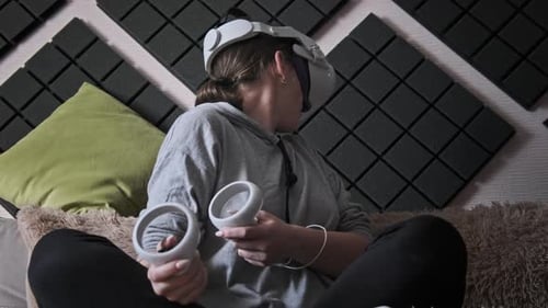 Young Adult Using Virtual Reality Headset with Controllers