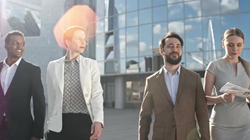 Diverse Team Walks and Talks by Modern Building