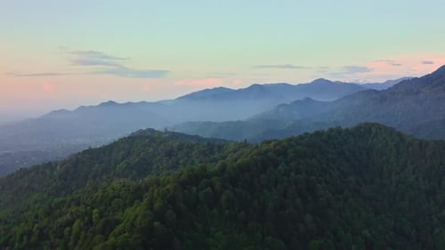 Drone view of forest hill ranges and foggy valleys at evening dawn