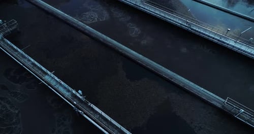 Aerial view of separated sewage containers, camera moving up.