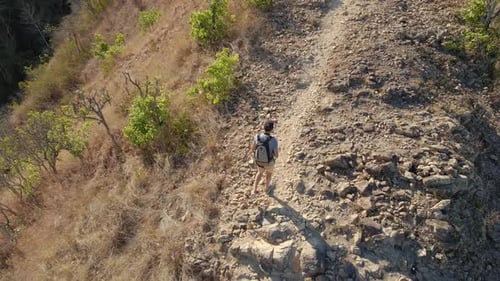 Person Hikes Mountain Ridge on Sunny Day