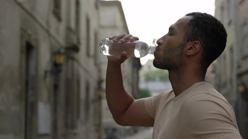 Side View of the Man Runner Drinking Water After the Scamper