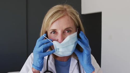 Woman Doctor Putting on a Surgical Mask