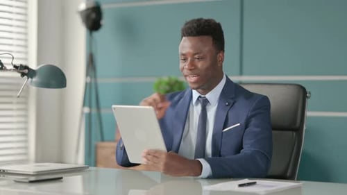 African Businessman Making Video Call on Tablet in Office