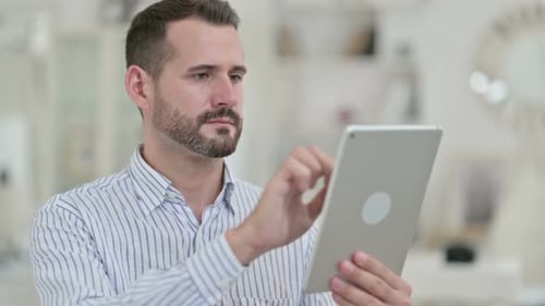 Man Uses Tablet Device in Bright Indoor Setting