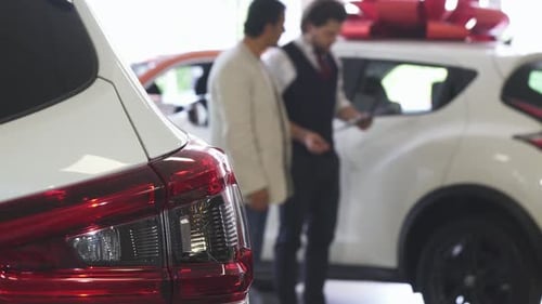 Car Salesman Talking to Customer in Dealership