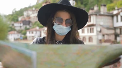 Woman Wearing Mask Looking at Map Outside