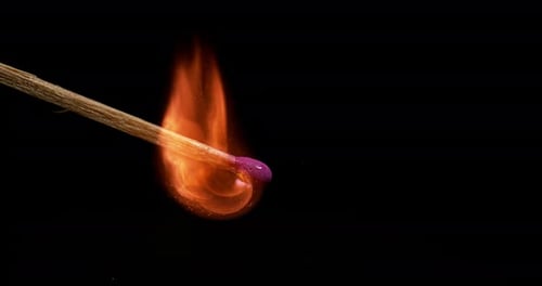 Match Igniting with Vivid Flame on Black Background